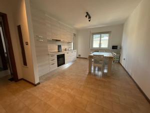 una cucina con tavolo e sala da pranzo di Casa di Tom con balcone, parcheggio e self check in a Trento Altre 23 foto