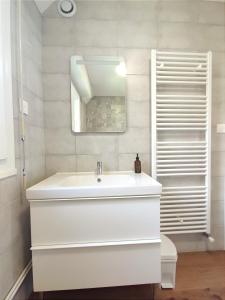a white bathroom with a sink and a mirror at Le Balnéo Duplex avec balcon - Riva Bella Plage in Ouistreham