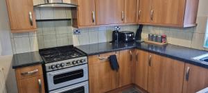 a kitchen with wooden cabinets and a stove top oven at A nice home in Liverpool in Liverpool +13 photos