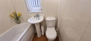a bathroom with a toilet and a sink and a bath tub at A nice home in Liverpool in Liverpool