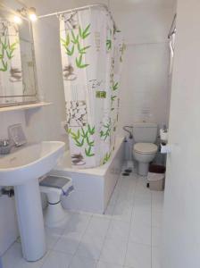 a bathroom with a sink and a toilet and a shower curtain at Sissi Mare Apartments in Sissi