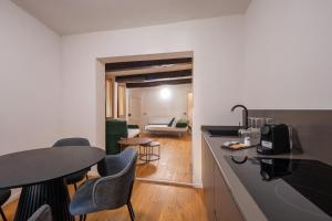 フィレンツェにあるPalazzina Fusiのテーブルと椅子のあるキッチンとリビングルーム