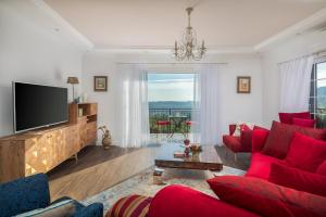 a living room with red furniture and a flat screen tv at Villa Zvonimir in Klis