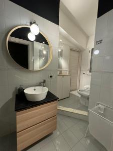une salle de bain avec un lavabo et un miroir et des toilettes dans l'établissement Moonlight house a 50 mt dal mare Noto Marina, à Noto Marina 39 autres photos