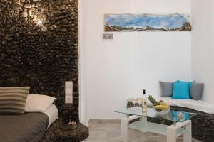 un soggiorno con un divano e un tavolo di vetro di Ichor Suites a Firà
