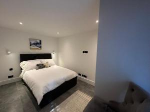 Un dormitorio con una cama grande con sábanas blancas. en House - Sleeps 4 & Free Parking, en Londres
