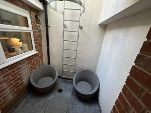 Un baño con dos inodoros y una escalera al lado de un edificio. en House - Sleeps 4 & Free Parking, en Londres 6 fotos más