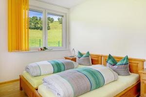 two beds in a room with a window at Sport Rees - Ferienwohnung Ulrike in Hofsgrund