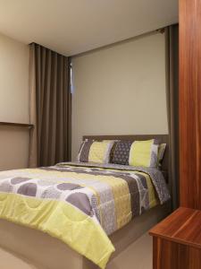 a bedroom with a bed with yellow and gray blankets at Adria Residences - Diamond Garden - 2 Bedroom Unit for 4 Person in Manila +24 photos
