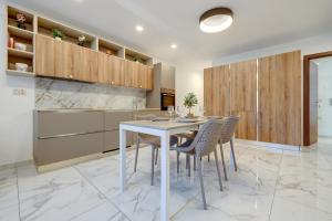 a kitchen with a white table and chairs at Stylish 2BR Getaway Steps from the Promenade in Sliema