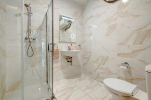 a bathroom with a shower and a toilet and a sink at Stylish 2BR Getaway Steps from the Promenade in Sliema
