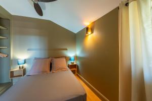 a bedroom with a bed with two lamps on it at Le Mas des Aracil 2 - Appt climatisé avec piscine in Suze-la-Rousse +6 photos