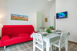 a living room with a red couch and a table at Casa Vacanze L'Aspidistra - Happy Rentals in Rutigliano
