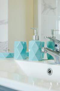 a bathroom sink with two soap dispensers and a mirror at Viriato's House in Ribeira Grande