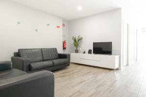 a living room with a couch and a flat screen tv at Viriato's House in Ribeira Grande