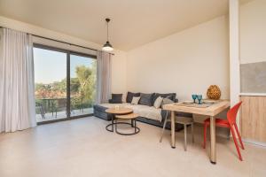 a living room with a couch and a table at Arangia Garden Maisonette in Kaká Pinári