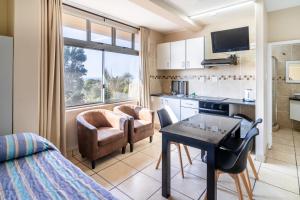 a small room with a kitchen and a table and chairs at ATKV Natalia in Kingsborough