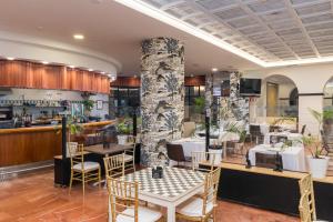 un restaurante con mesas y sillas y un pilar de piedra en Hotel Milagros Golf, en Mogro