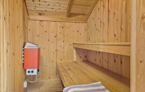 l'intérieur d'un sauna en bois avec un appareil rouge dans l'établissement Awesome Home In Løkken With Kitchen, à Løkken 20 autres photos