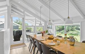 une salle à manger avec une grande table et des chaises en bois dans l'établissement Awesome Home In Løkken With Kitchen, à Løkken