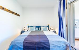 a bedroom with a blue and white bed with a window at Amazing Apartment In Fazana With Wifi in Fažana