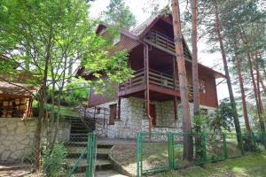 a house in the woods with a green fence at Willa Jodełka in Majdan Sopocki