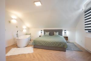 ein Schlafzimmer mit einem Bett und einer Badewanne neben einem Bett sidx sidx sidx in der Unterkunft Lux Loft Spa in Rakovica