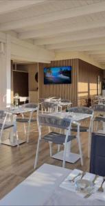 a dining room with white tables and chairs and a tv at Palazzo Firenze in Naples