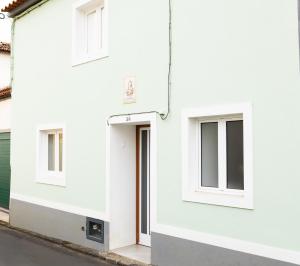 a white house with a door and windows at Viriato's House in Ribeira Grande