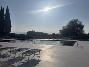 a pool with two tables and chairs next to it at Garda Golf Studio in Soiano del Lago