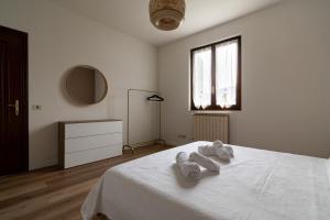 a white bedroom with a bed with towels on it at Casa vacanze Il Pescheto in Concesio