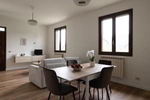 a dining room and living room with a table and chairs at Casa vacanze Il Pescheto in Concesio