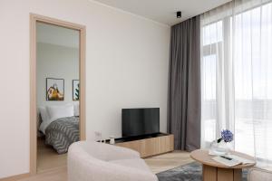 a living room with a tv and a bed and a mirror at Bob W Tallinn Kesklinn in Tallinn