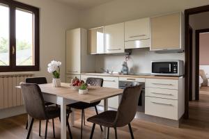 a kitchen with a table and chairs and a microwave at Casa vacanze Il Pescheto in Concesio