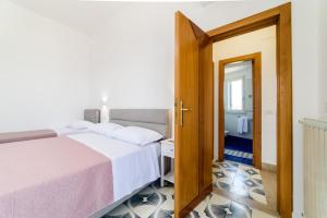 a bedroom with a bed and a door leading to a bathroom at Relais Francesca Pool&View in Sorrento +55 photos
