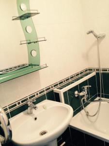 ein Bad mit einem Waschbecken und einem Spiegel in der Unterkunft ЛЮКС на Юго-востоке,Степной1 in Qaraghandy