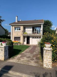 a white house with a balcony and a walkway at Charmante maison au calme proche de Paris in Achères