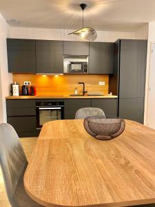 una cocina con mesa de madera y sillas. en T2 Rez-de-chaussée, Le Victor Hugo, en Cancale