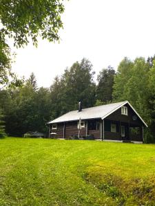 TöcksforsにあるKoselig hytte i Sverige 20 minutter fra norskegrensen Ostervallskogの緑草原の丸太小屋