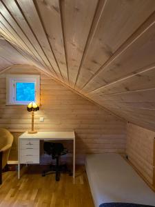 TöcksforsにあるKoselig hytte i Sverige 20 minutter fra norskegrensen Ostervallskogのデスクとベッド付きの屋根裏部屋
