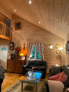 TöcksforsにあるKoselig hytte i Sverige 20 minutter fra norskegrensen Ostervallskogのリビングルーム(革製家具、木製の天井付)