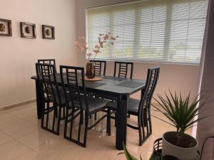 a black dining room table with chairs and a window at SOPAN in Laganas