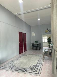 a living room with a red door and a table at RUMAH INAP 09 in Arau +22 photos