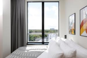 a bedroom with a white bed with a large window at Bob W Tallinn Kesklinn in Tallinn