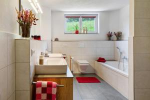a bathroom with a sink and a tub and a toilet at Fewo Schwarzwaldflair mit Eventraum in Hofsgrund +29 photos