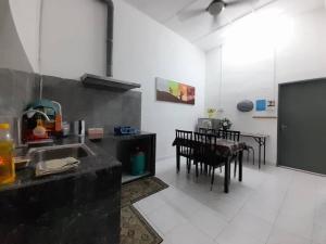 a kitchen with a sink and a table with chairs at Mukhriz 2 Homestay in Kulim