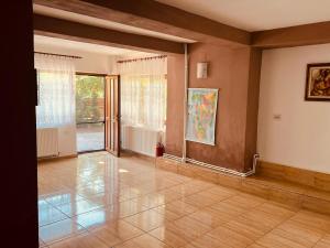 an empty living room with a large glass door at Pensiunea Valu in Bărbăteşti