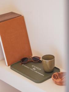 a tray with glasses and a cup on it at Hôtel Liautaud Rooftop Cassis in Cassis