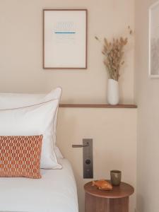 a bedroom with a bed and a table with a picture at Hôtel Liautaud Rooftop Cassis in Cassis