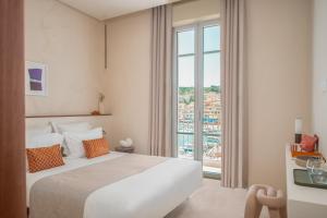 a hotel room with a bed and a large window at Hôtel Liautaud Rooftop Cassis in Cassis +37 photos